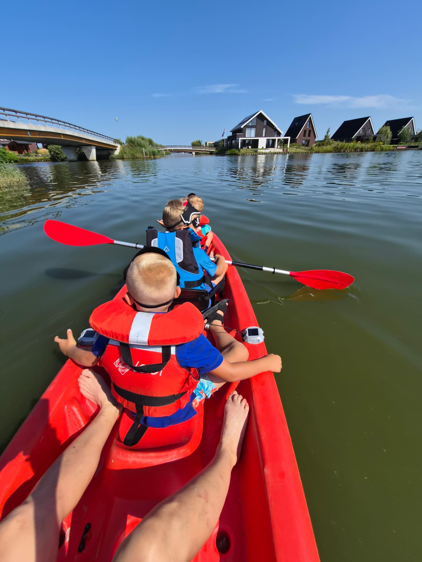 Familie met kinderen in een rode kayak op het Oldambtmeer